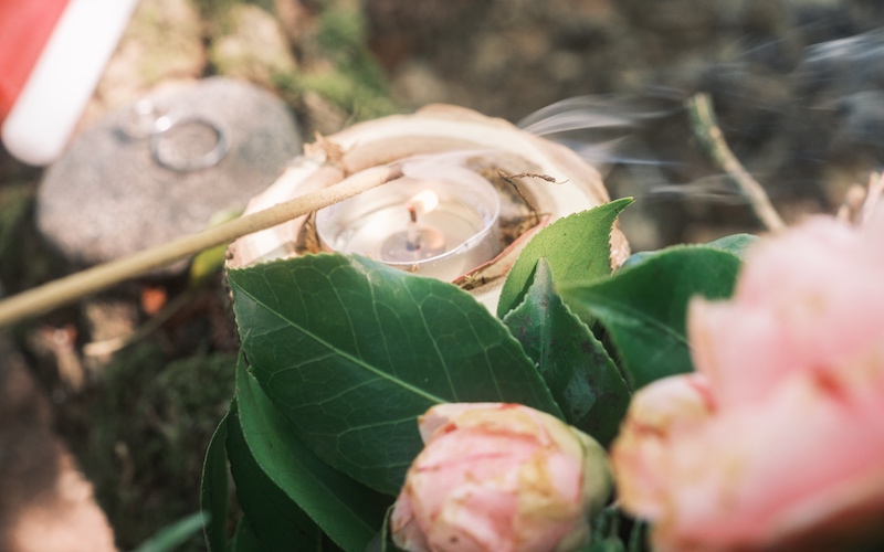 Incenso sopra la fiamma di una candela in mezzo alle rose