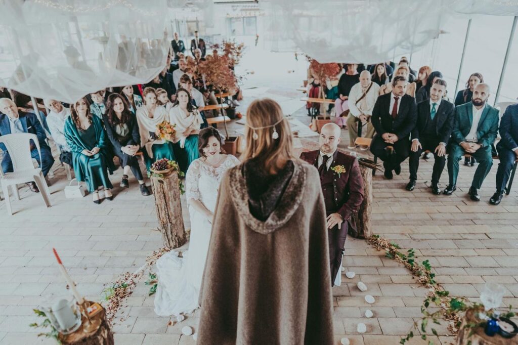 Una celebrante davanti a due sposi celebra un matrimonio celtico in natura